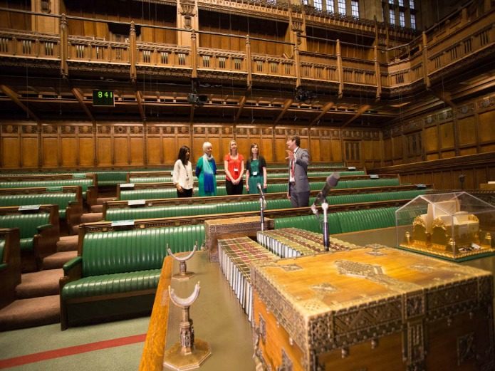 Palace of Westminster - Part view of ornate Victorian gothic architecture of the iconic Big Ben clock tower at the Houses of Parliament, designed by Sir Charles Barry and Augustus Pugin.