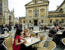 Bath - Two women sitting at a table talking outside Binks Cafe, Abbey Courtyard in the busy city of Bath., Bath, Bath and North East Somerset, England.