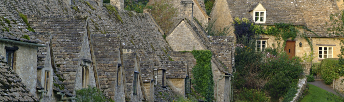 Quaint stone cottages in the Cotswold village of Bibury, Bibury, Gloucestershire, England.