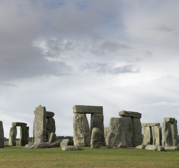 Stonehenge is a pre-historic henge and national landmark on the Wiltshire plain. It is a stone circle of standing stones, with some stones placed horizontally across the top of vertical stones. It is a UNESCO world heritage site. Gathering clouds over the site.