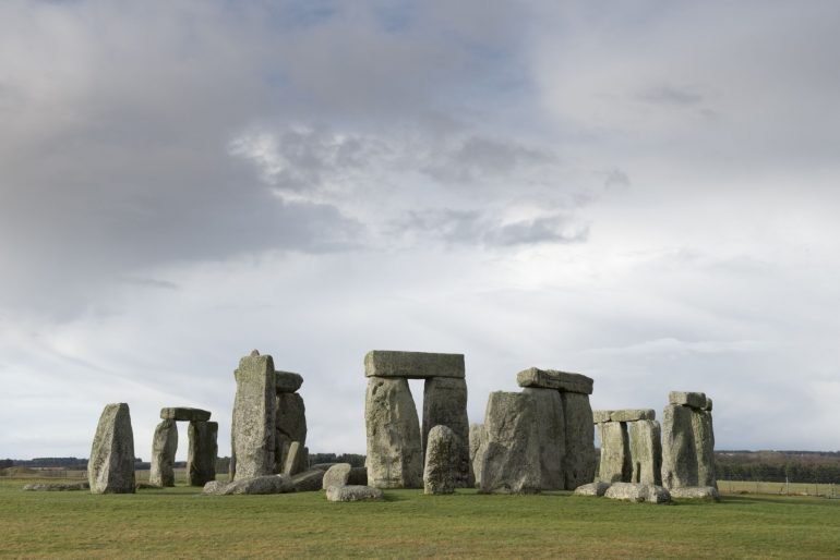 Stonehenge is a pre-historic henge and national landmark on the Wiltshire plain. It is a stone circle of standing stones, with some stones placed horizontally across the top of vertical stones. It is a UNESCO world heritage site. Gathering clouds over the site.