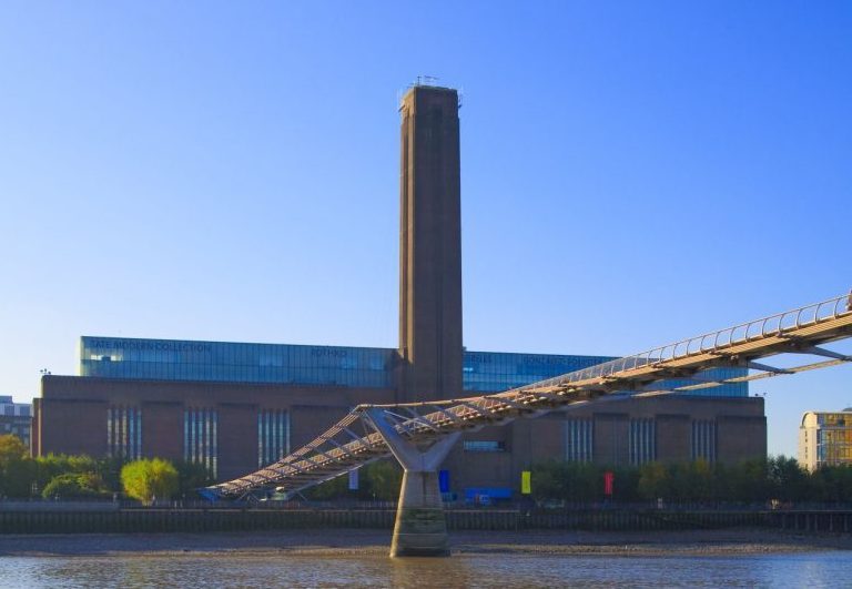 Tate Modern: View from the banks of the Thames River with Millennium Bridge in forefront.