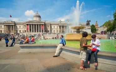 Tourist hanging out in Trafalgar Square with the National Gallery in the backdrop. Photo Credit: ©London & Partners.