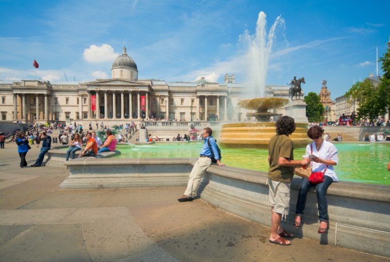 Tourist hanging out in Trafalgar Square with the National Gallery in the backdrop. Photo Credit: ©London & Partners.