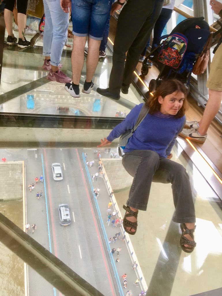 Young lady sitting on glass floor at Tower Bridge in London. Photo Credit: © Edwin Lerner.