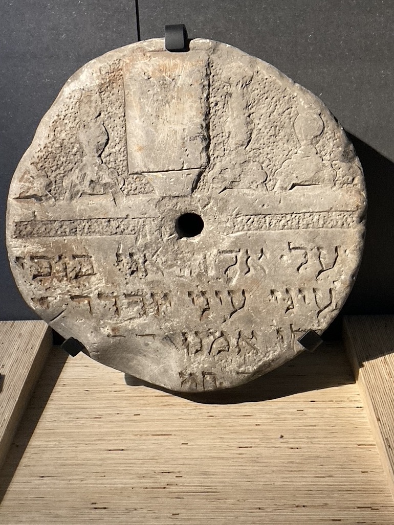 Jewish gravestone re-used as millwheel at Imperial War Museum in London. Photo Credit: © Rick Jones.