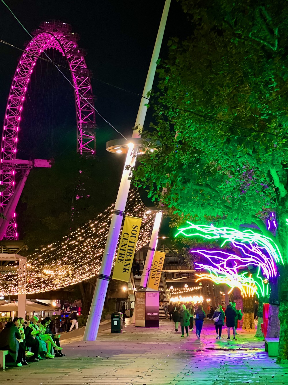 View of the London Eye and Loomin, an electric neon canopy sculpted by David Ogle along Queen’s Walk near South Bank Centre in London. Photo Credit: © Ursula Petula Barzey.